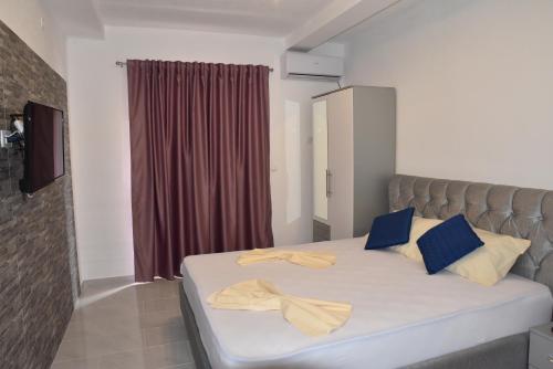 a bedroom with a bed with blue and yellow pillows at Vila Cattleya in Donji Štoj