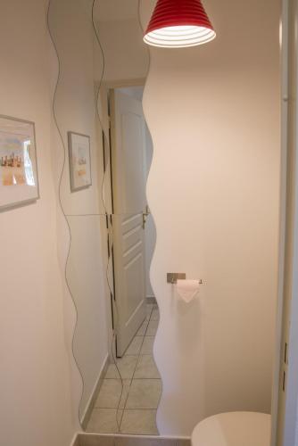 a bathroom with a toilet and a light on the wall at Petit nid douillet Décines in Décines-Charpieu