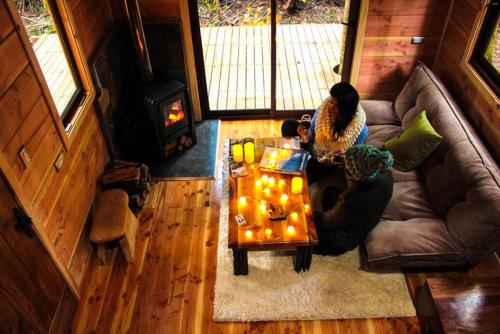a living room with a couch and a coffee table at Cabañas Bosque Milenario in Coñaripe