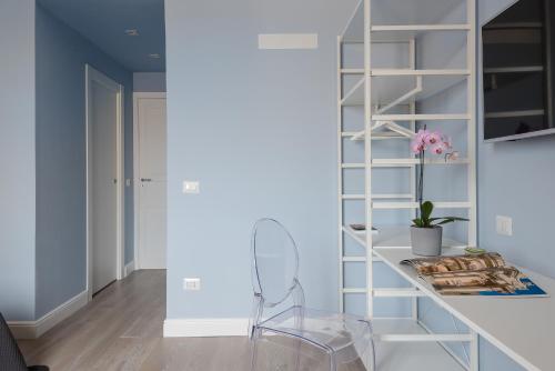 a white shelving unit in a living room with a chair at D-Home Ortigia in Siracusa