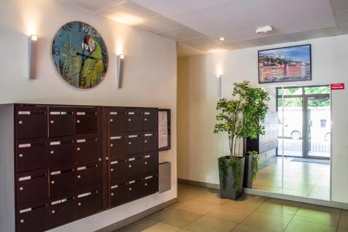 a room with lockers and a clock on the wall at Petit nid douillet Décines in Décines-Charpieu