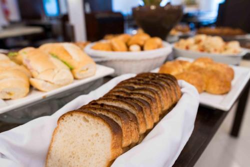 a table topped with plates of bread and pastries at Plaza Caldas da Imperatriz Resort & Spa in Santo Amaro da Imperatriz