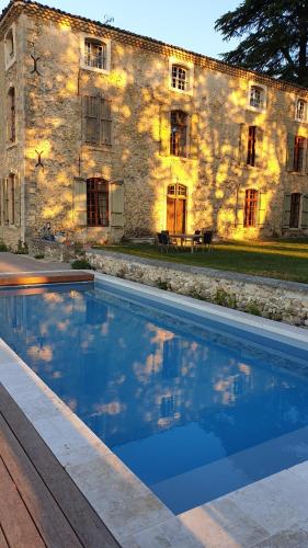 une maison avec piscine devant un immeuble dans l'établissement la bastide de l'adrech, à Manosque