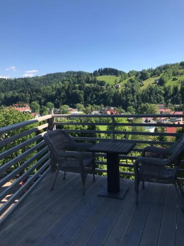 a table and two chairs on a deck with a view at Kwaterka in Brenna
