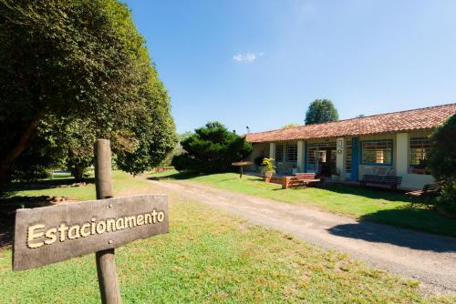 a sign in front of a building with a house at Hotel Alto da Boa Vista in Analândia