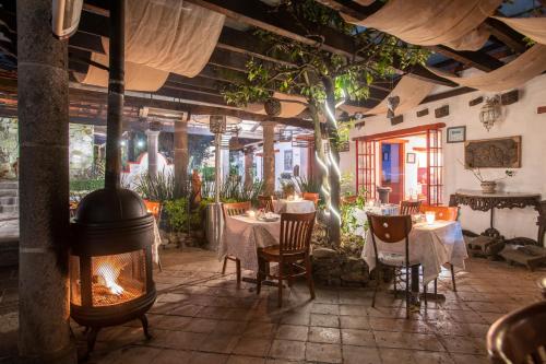 a restaurant with a fireplace and tables and chairs at La Casa Azul Huasca & Restaurante La Terraza in Huasca de Ocampo