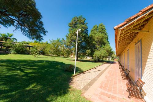 a park with a bench next to a building at Hotel Alto da Boa Vista in Analândia