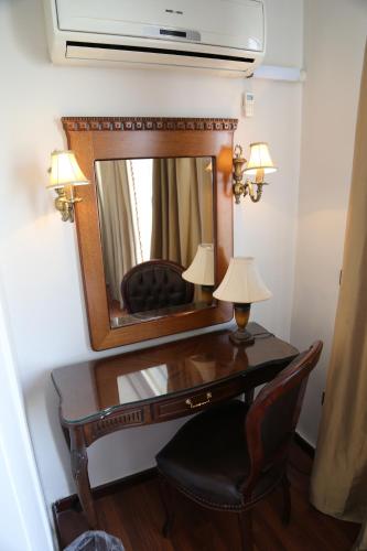 
a room with a mirror, a chair and a lamp at Gondola Hotel & Suites in Amman
