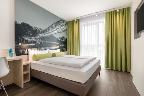 a bedroom with a bed and a large window at Super 8 by Wyndham Oberhausen am Centro in Oberhausen