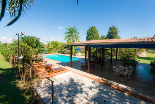 an outdoor patio with a pool and a pavilion at Hotel Alto da Boa Vista in Analândia