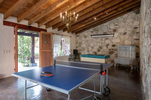 a ping pong table in a room with a stone wall at La Casa Azul Huasca & Restaurante La Terraza in Huasca de Ocampo