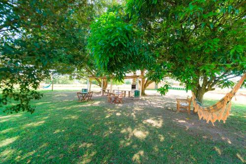 a hammock under a tree in a park at Hotel Alto da Boa Vista in Analândia