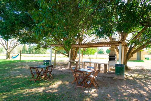 a picnic table and chairs under a tree at Hotel Alto da Boa Vista in Analândia