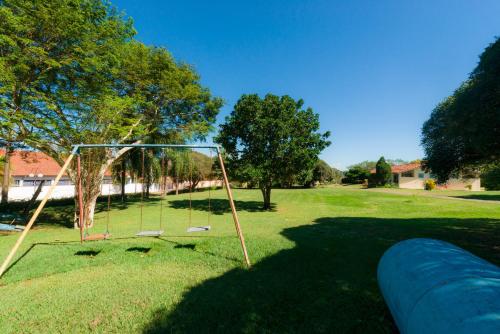 a swing set in a field of grass at Hotel Alto da Boa Vista in Analândia