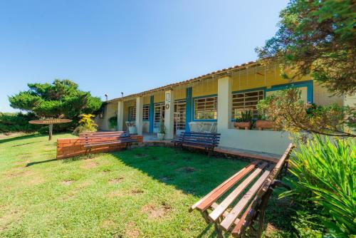 a building with benches in front of it at Hotel Alto da Boa Vista in Analândia