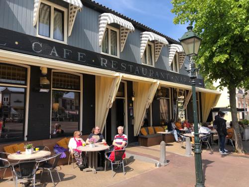 a group of people sitting at tables outside of a building at Hotel Nap in West-Terschelling