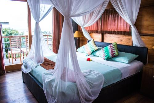 1 dormitorio con 1 cama con mosquiteras en Bali Green Hills, en Uluwatu