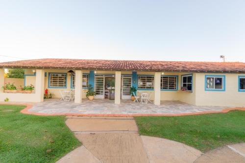 a house with a patio and lawn in front of it at Hotel Alto da Boa Vista in Analândia