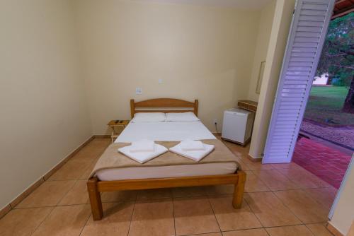 a bedroom with a bed with two pillows on it at Hotel Alto da Boa Vista in Analândia