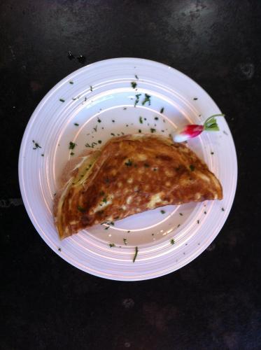 een wit bord met een stuk pizza erop bij Genelle House B&B Guest House in Genelle