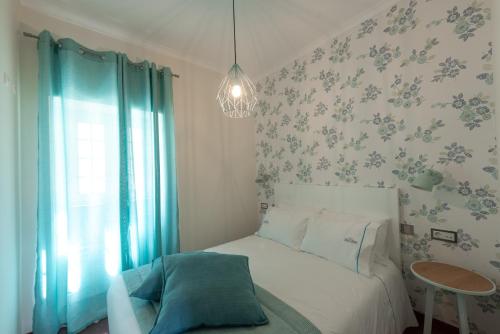 a bedroom with a bed and a table and a window at Casa Poesia in Castanheira de Pêra