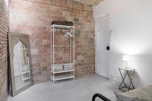 a room with a brick wall and a mirror at Magic Apartment with Private Terrace in Barcelona