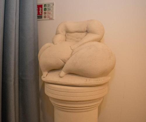 a statue of a woman in a vase on a wall at Kikka B&B in Tarxien