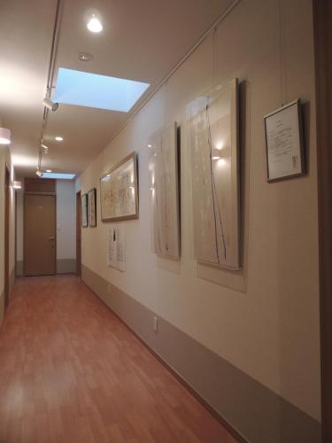 a hallway with art on the walls of a building at B&B Hotel Hyochoan in Karuizawa