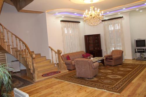 a living room with stairs and chairs and a chandelier at Luxury Villa with pool and waterfall in Bina