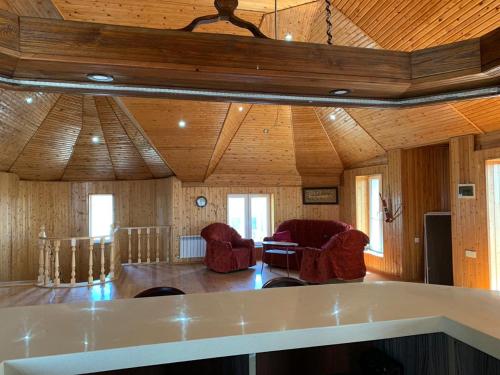 a living room with red chairs and a wooden ceiling at Luxury Villa with pool and waterfall in Bina