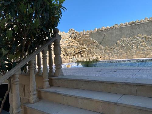 a set of stairs leading up to a stone wall at Luxury Villa with pool and waterfall in Bina