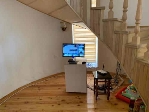 a living room with a television and a staircase at Luxury Villa with pool and waterfall in Bina