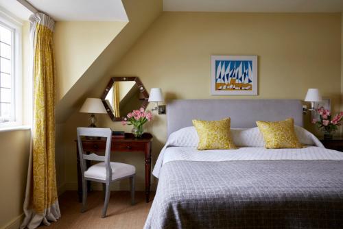 a bedroom with a bed and a desk with a mirror at Hotel Tresanton in Saint Mawes