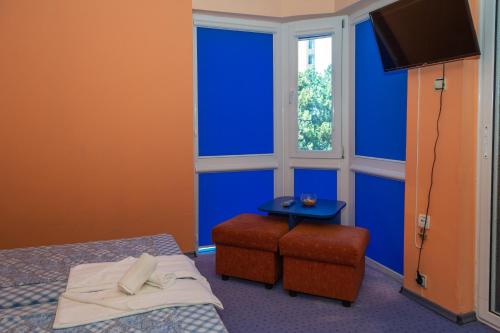 a bedroom with blue walls and a bed and a stool at Dara Hotel in Primorsko