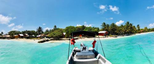 a boat in the water next to a beach at Sunrise Paradise/Carlito´s Place in Corn Island