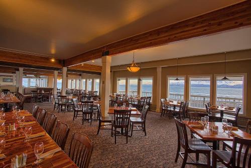 a restaurant with tables and chairs and a view of the ocean at Land's End in Homer