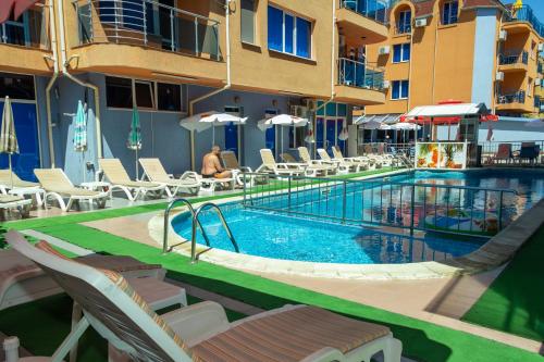 a swimming pool with chairs and a hotel at Dara Hotel in Primorsko