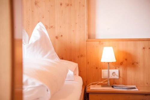 a bedroom with a bed with white sheets and a lamp at Appartement Omesberg 1 in Lech am Arlberg