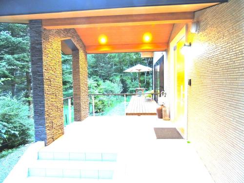 an outside view of a house with stairs and an umbrella at B&B Hotel Hyochoan in Karuizawa