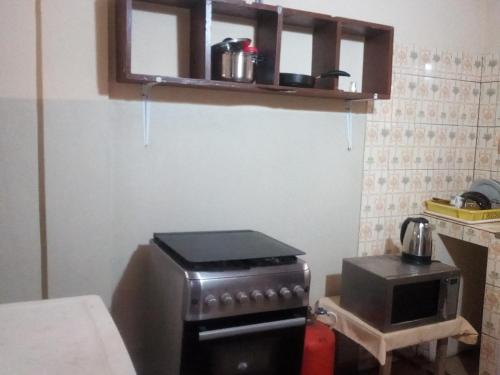 a small kitchen with a stove and a microwave at Marys Guest House in Lomé