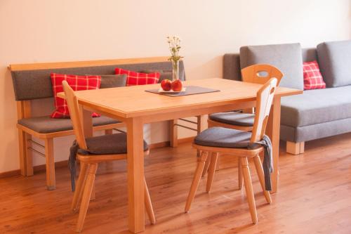 a wooden table and chairs with a bowl of fruit on it at Appartement Omesberg 1 in Lech am Arlberg