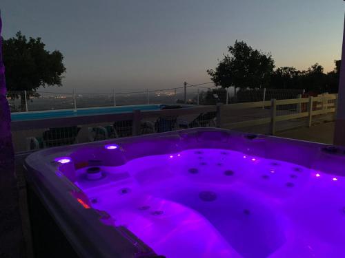 a purple hot tub with purple lights on a balcony at Luar do Cano in Monchique