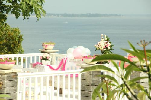 a white fence with pink and white balloons and flowers at Princess of Mentigi Bay in Teluk Nara