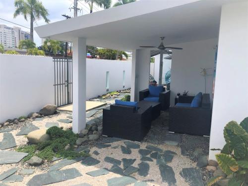 a patio with two blue chairs under a white umbrella at MAR DEL NORTE in San Juan