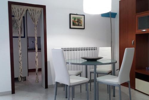 a dining room with a table and white chairs at Il Balcone di Giulietta in Locorotondo