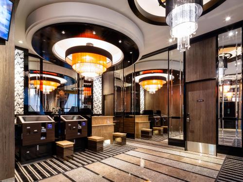 a lobby of a hotel with chandeliers and tables at APA Hotel Komagome Ekimae in Tokyo