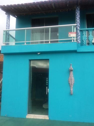 um edifício azul com uma estátua ao lado dele em Apartamentos no Farol Velho em Salinópolis