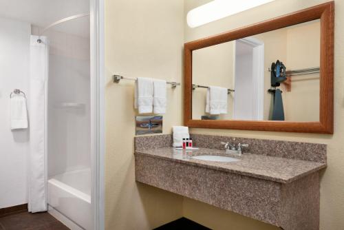 a bathroom with a sink and a mirror at Ramada by Wyndham Spokane Airport in Spokane
