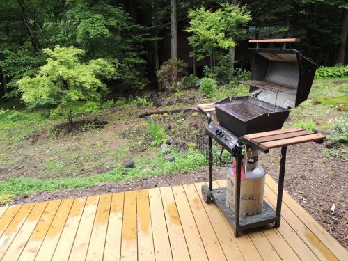 a grill sitting on a wooden deck in a yard at B&B Hotel Hyochoan in Karuizawa