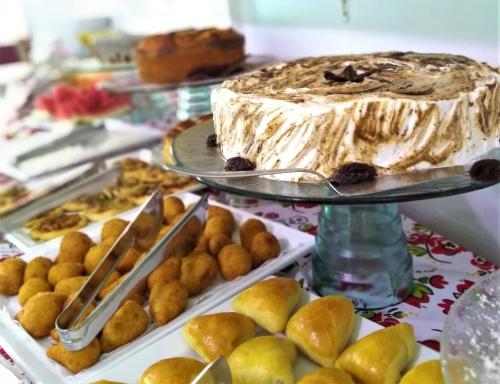 a cake on a plate on a table with pastries at Simas Praia Hotel in Aracaju